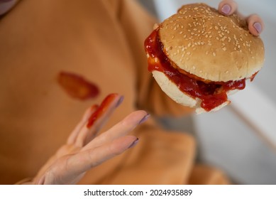 Caucasian Young Woman Eating Burger And Getting Dirty In Ketchup. Sloppy Girl