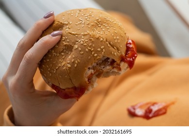 Caucasian Young Woman Eating Burger And Getting Dirty In Ketchup. Sloppy Girl