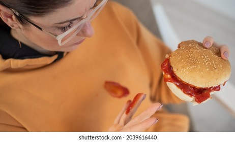 Caucasian Young Woman Eating Burger And Getting Dirty In Ketchup. Sloppy Girl