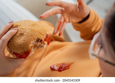 Caucasian Young Woman Eating Burger And Getting Dirty In Ketchup. Sloppy Girl