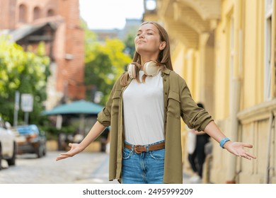 Caucasian young woman taking a deep breath of fresh air, relaxing, taking a break, resting, meditating, calm down outdoors. Girl enjoying happy day standing in urban city street. Town lifestyles. - Powered by Shutterstock