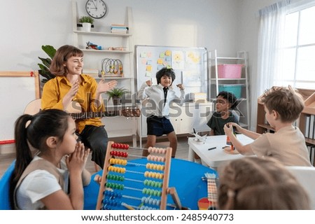Caucasian young woman teacher playing guitar with students in school. Adorable little children having fun enjoy education activity, dance with instrument in classroom at preschool nursery kindergarten