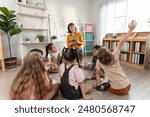 Caucasian young woman teacher teaching student in classroom at school. Attractive beautiful female instructor master explain and educate children with fun activity at preschool nursery kindergarten.