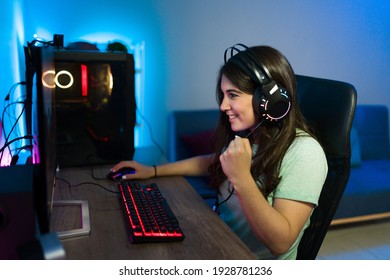 Caucasian Young Woman Winning A Victory In A Video Game And Feeling Excited While Sitting At Her Gaming Computer PC