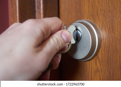 Caucasian's hand with key opening door