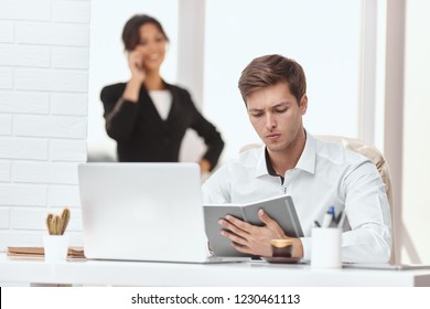 Caucasion Man And Woman Working Together In A Modern Office