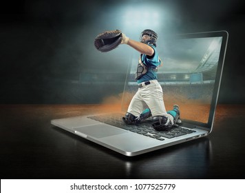 Caucassian baseball Player in dynamic action with ball in a professional sport game play on the laptop in baseball under stadium lights.