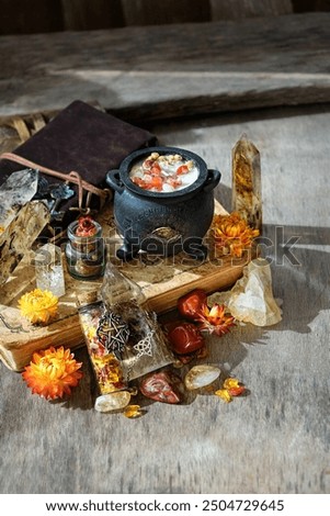 Cauldron, amulets, witchcraft items, spell books and gemstone crystals on wooden table. Witchcraft, crystal magic. energy healing spiritual, esoteric ritual for relax, meditation. practical magic