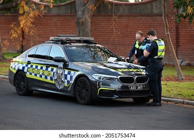 Caulfield South, Victoria, Australia - May 18 2021: A Victoria Police Highway Patrol BMW M5 Parked On The Side Of The Road, While Two Police Officers Perform Their Duties