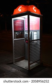 Caulfield South, Victoria, Australia - October 17 2021: A Telstra payphone at night, with signature orange illumination on the top of the booth