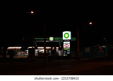 Caulfield South, Victoria, Australia - October 18 2022: Suburban BP Service Station And IGA Xpress At Night, With Brightly Illuminated Signs, Seen From Across An Intersection