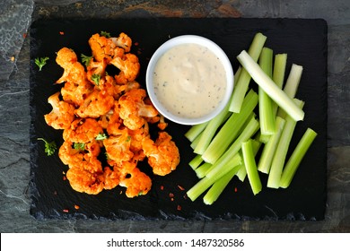 Cauliflower Buffalo Wings With Celery And Ranch Dip. Top View On A Slate Serving Platter. Healthy Eating, Plant Based Meat Substitute Concept.