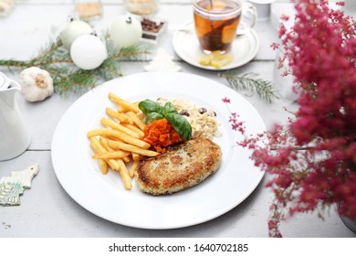 Cauliflower Cutlet Served With Fries And Carrot And Celery Salad.  Appetizing Dish. Ready Meal On A Plate. Suggestion Of Serving Food.