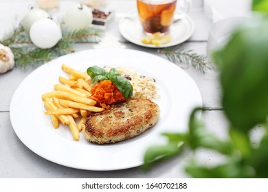 Cauliflower Cutlet Served With Fries And Carrot And Celery Salad.  Appetizing Dish. Ready Meal On A Plate. Suggestion Of Serving Food.