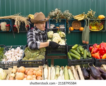 Cauliflower At The Farmers' Market. A Male Salesman Places A Box Of Cauliflower On The Counter.
The Seller In A Protective Medical Mask.