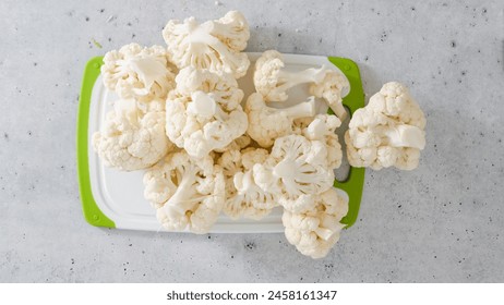 Cauliflower florets close-up on cutting board on grey stone background, flat lay - Powered by Shutterstock