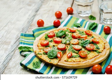 Poussière de pizza au chou-fleur avec tomate et épinards. toning. mise au point sélective