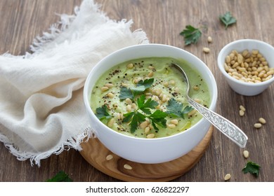 Cauliflower Puree Soup With Parsley And Pine Nuts In A White Bowl On A Wooden Table. Delicious Diet Food