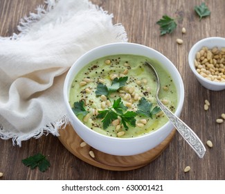 Cauliflower Puree Soup With Parsley And Pine Nuts In A White Bowl On A Wooden Table. Delicious Diet Food