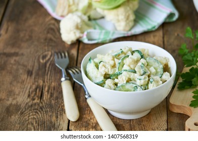 Cauliflower salad with cucumbers and eggs on a wooden background                              
