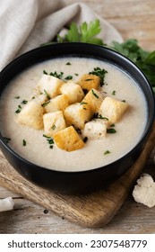 Cauliflower soup in a bowl on wooden table - Shutterstock ID 2307548779