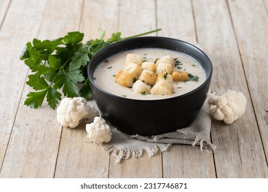 Cauliflower soup in a bowl on wooden table - Shutterstock ID 2317746871