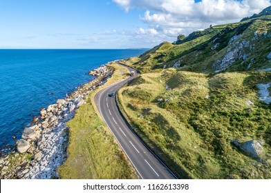 Causeway Coastal Route with cars, a.k.a. Antrim Coastal Road on eastern coast of Northern Ireland, UK. - Powered by Shutterstock