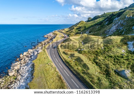 Causeway Coastal Route with cars, a.k.a. Antrim Coastal Road on eastern coast of Northern Ireland, UK.