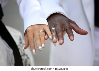Causian and African-American couple holding hand with ring