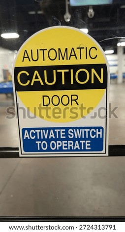Caution Automatic Door Activate Switch To Operate Label on a Glass Door