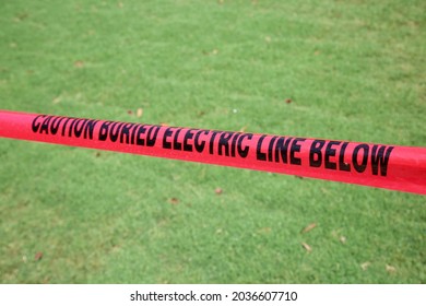 Caution Buried Electric Line Below. Caution Tape. Warning Tape. Danger Warning Tape. Electrical Lines Buried Under Ground. Electricity Hazard. Red Warning Caution Tape. 