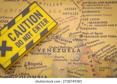 Caution Do Not Enter warning sign placed on Venezuela map with Caribbean and neighboring regions for geopolitical risk concept.
