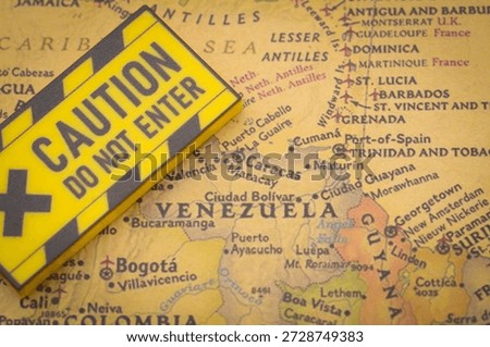 Caution Do Not Enter warning sign placed on Venezuela map with Caribbean and neighboring regions for geopolitical risk concept.