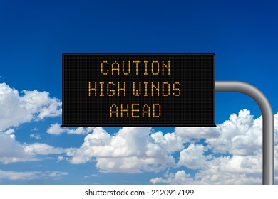 Caution High Winds Ahead variable highway sign with a cloudy sky