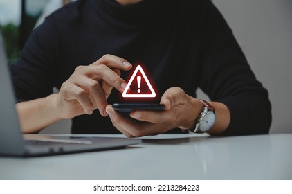 Caution in investing Economic situation warning, Phishing and internet security concept, Businessman using smartphone with warning sign.