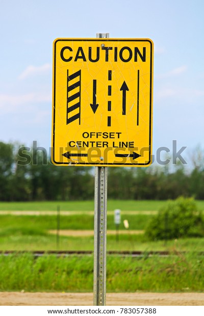 A caution offset
center line road sign.