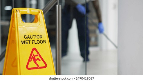 Caution, sign and cleaning for floor, janitor and hygiene service and dark at night in office. Mop, job and disinfection with equipment with warning and male person, disinfectant and wet ground - Powered by Shutterstock