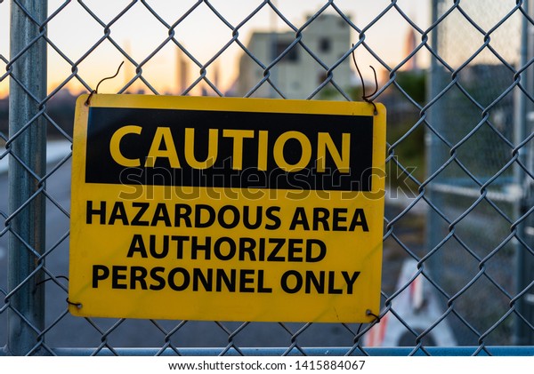 Caution sign for\
hazardous area on metal\
fence