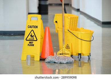 Caution Sign With Mop And Bucket On Office Floor