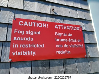 A caution sign telling when a fog horn will sound written in English and French. - Shutterstock ID 2230226787