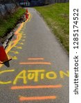 Caution spray painted on the crumbling Don River Valley bike path in Riverdale Toronto