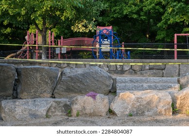 Caution tape around a closed playground play structure at the park in summer - Shutterstock ID 2284804087
