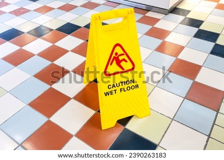 Caution Wet Floor yellow warning sign on a tile floor in a superstore
