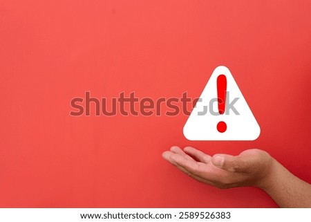 Caution,Critical Alert,Hazard Warning,Warning and notification concept.,Hand Holding Red Attention Sign Symbolizing Alertness, Emergency Notification, and Hazard Prevention.