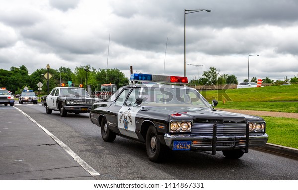 Cavalcade\
of vintage US police cars driving in front of the Jefferson\
Memorial in Washington DC, USA on 13 May\
2019