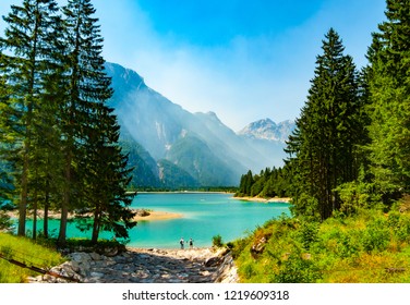 Cave Del Predil Lake Framed By Fir Trees With Haze Embracing Mountain Sides, Friuli, Italy