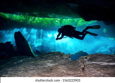 Cave Diver Diving Through The Lights In A Cenote In Mexico