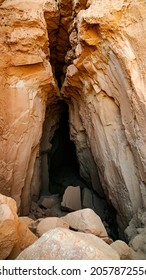The cave entrance of the Goblin's Lair cave in the Goblin Valley State Park on a hike in middle of the desert in Utah with large red rock's surrounding it.