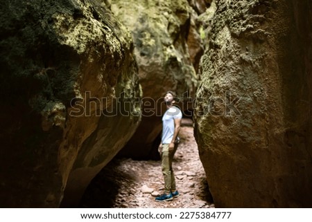 Cave exploration, exploring a cavern. Young woman explorer walks through a narrow path in caves and caverns in Estrecho de la Arboleja or Agualeja in Murcia, Spain.