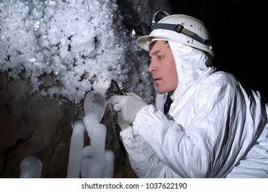 cave explorer carefully examines the structure of the ice formations through a magnifying glass